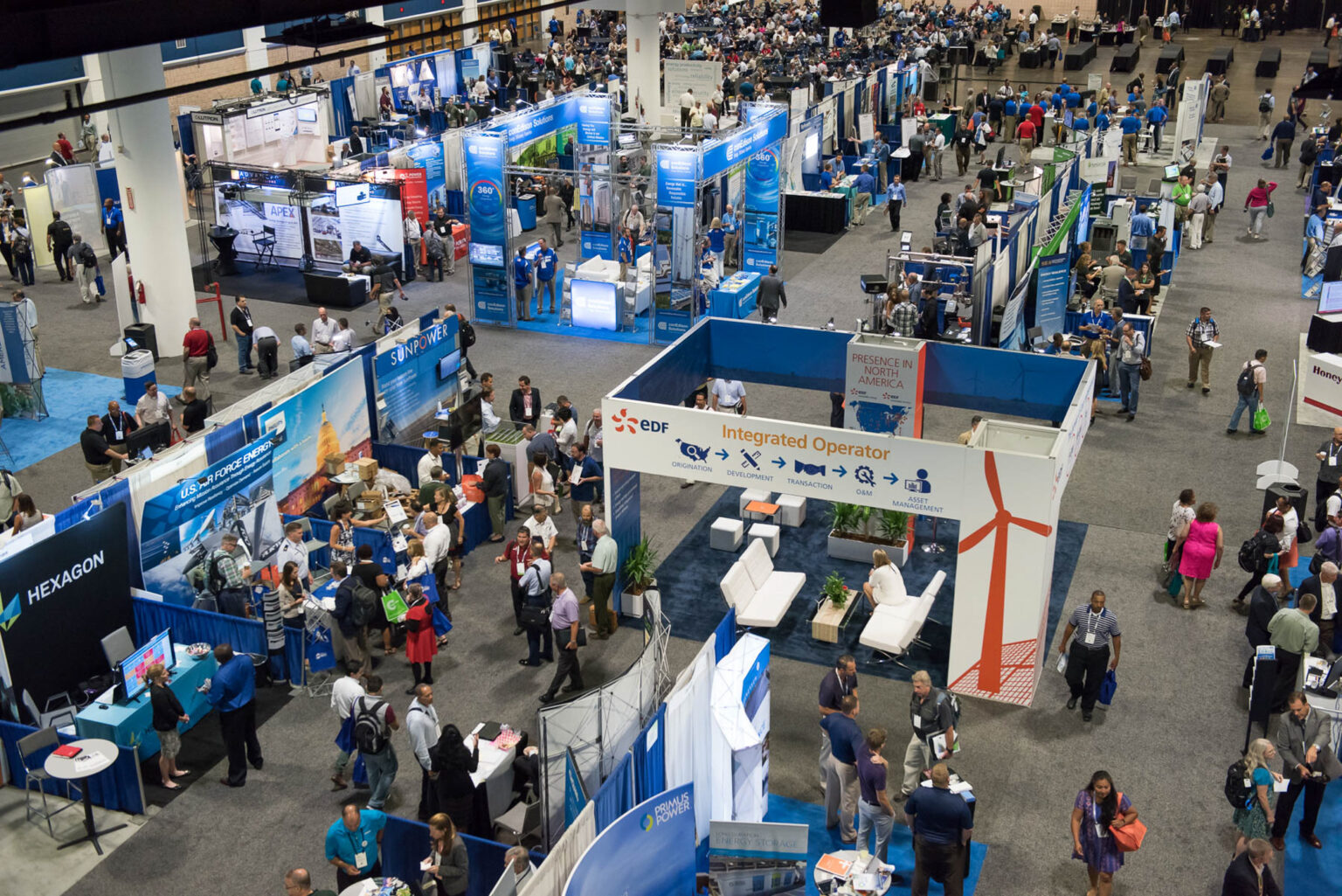 Busy trade show floor with modern exhibitor booths and engagement
